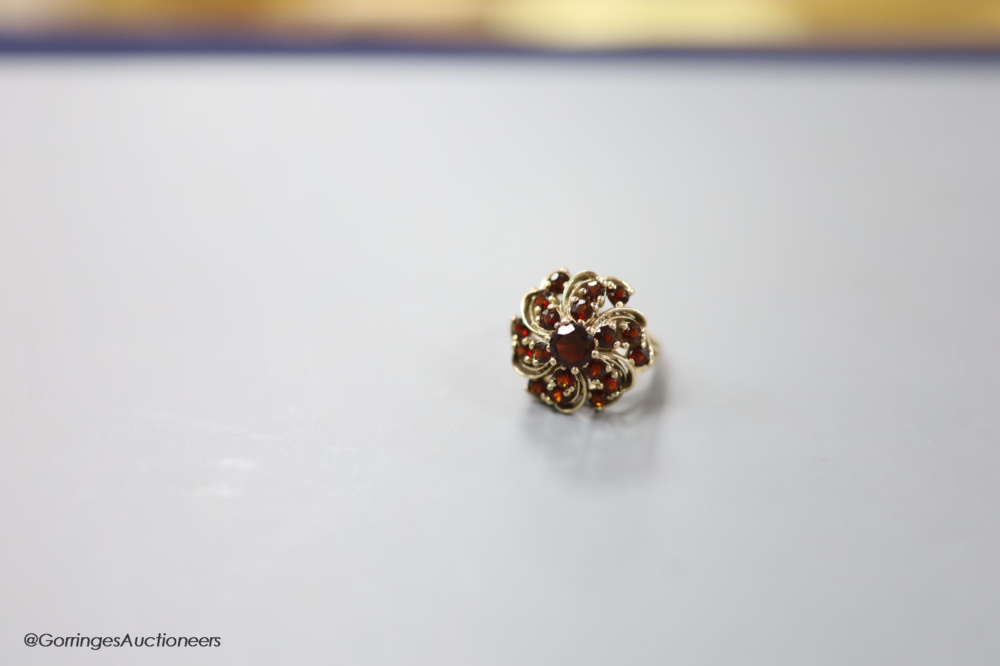 A modern 14ct gold and garnet cluster dress ring, size M/N, gross 7.4 grams
